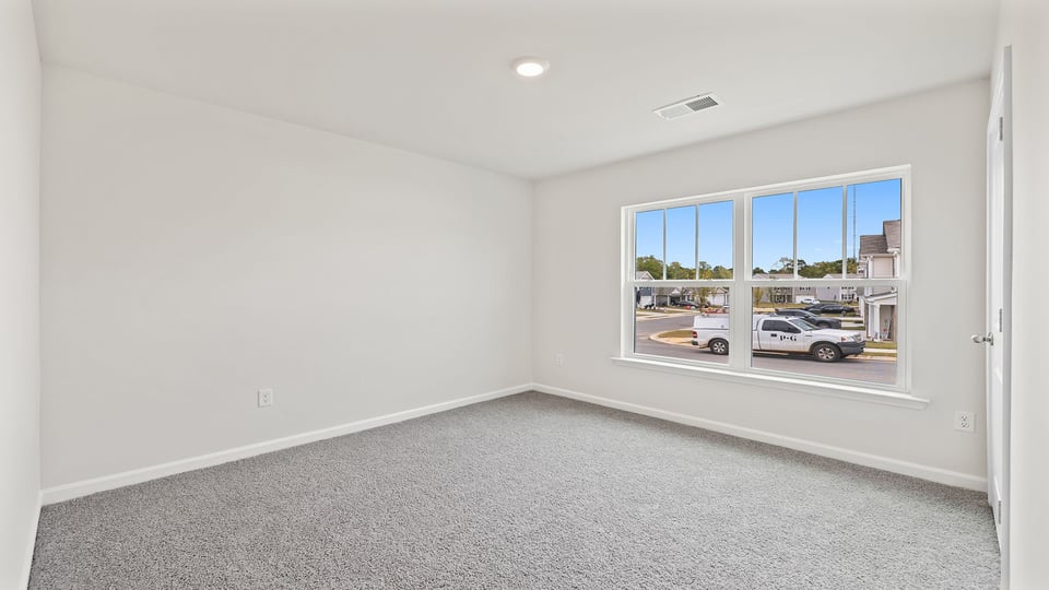 Bedroom with carpet and windows.
