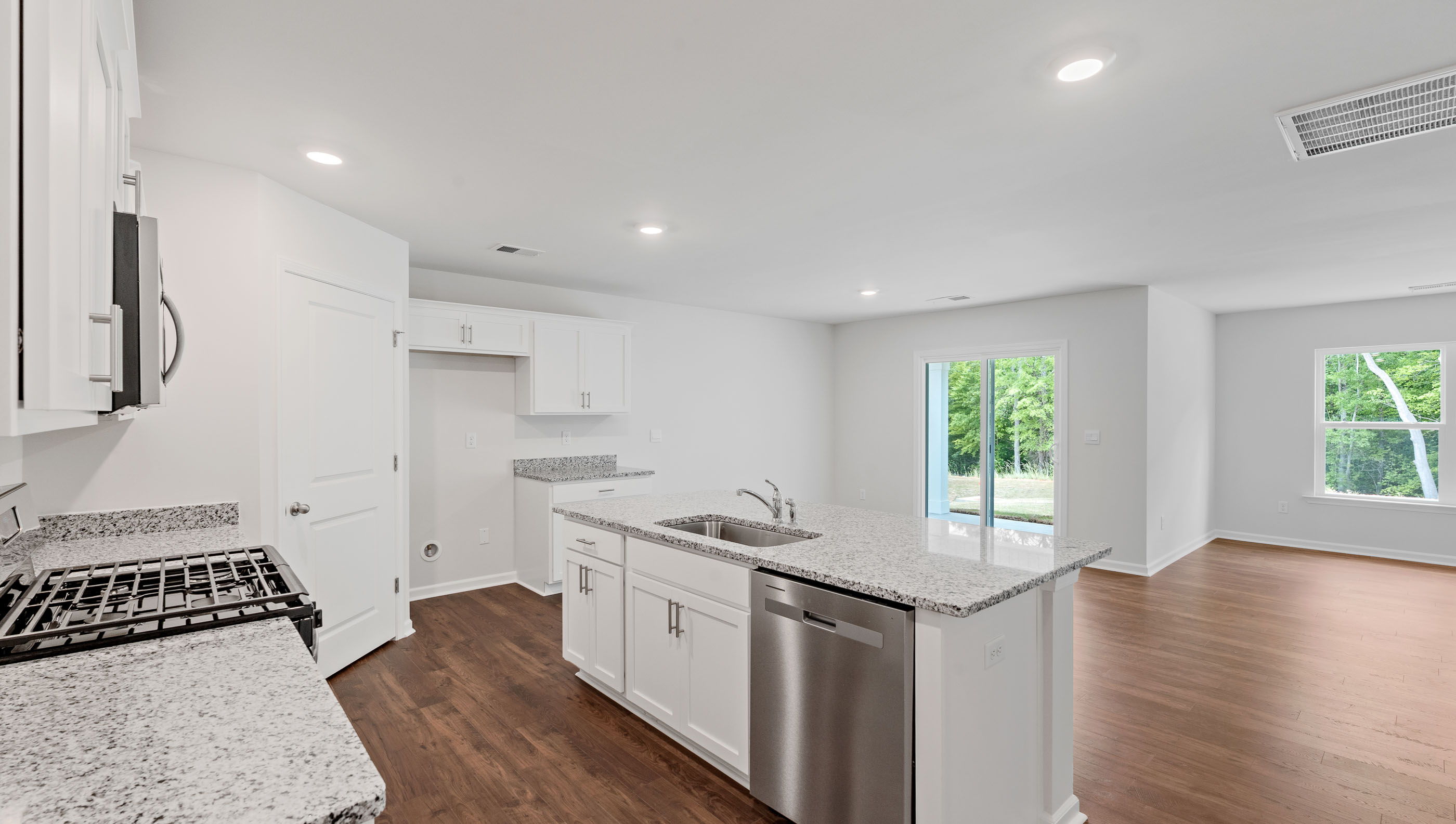 Kitchen and island with quartz countertops and  stainless steel appliances.