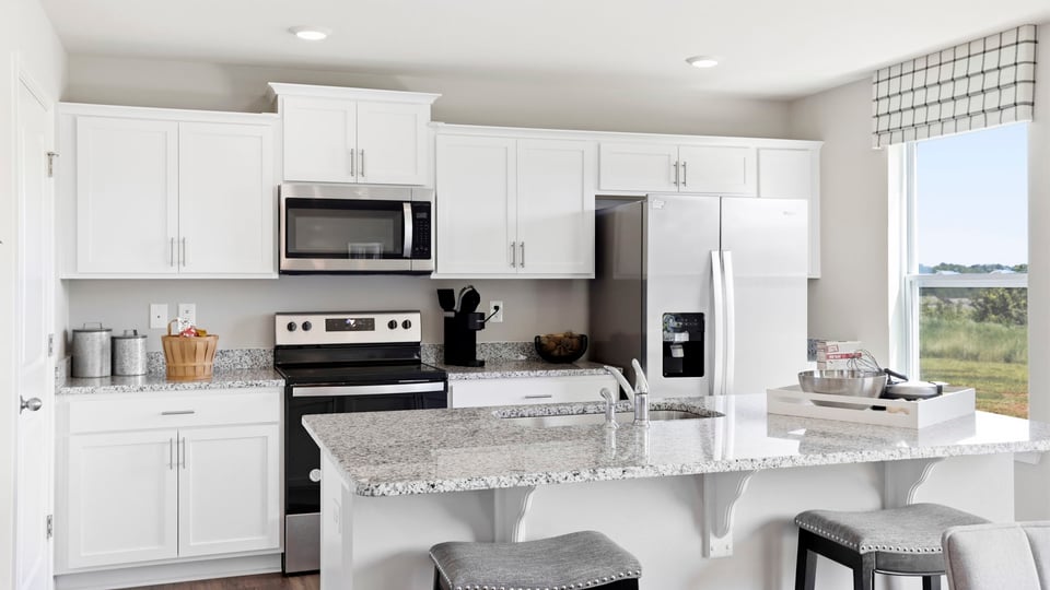 Kitchen and island with stainless steel appliances.