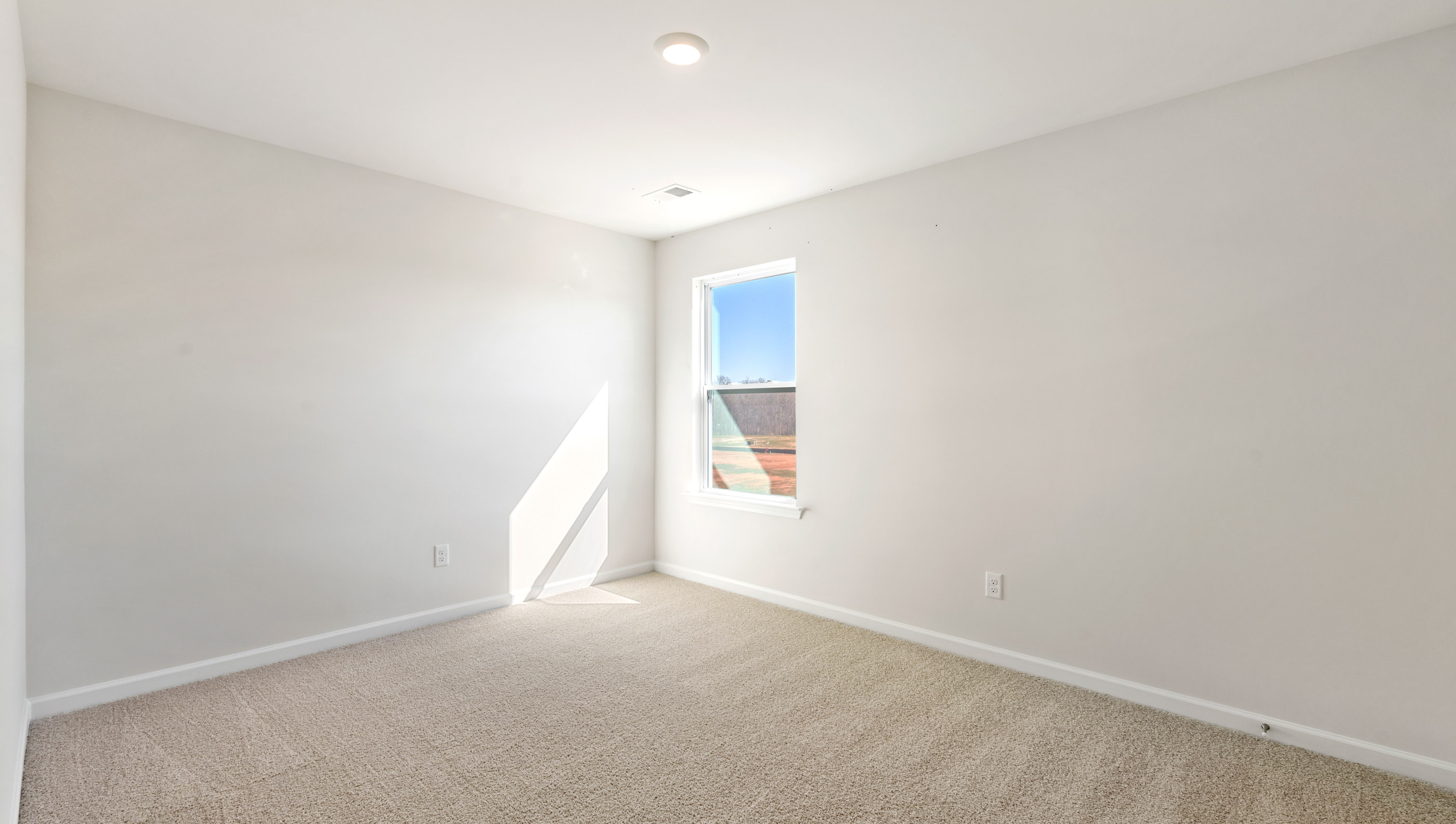 Bedroom with carpet and windows.