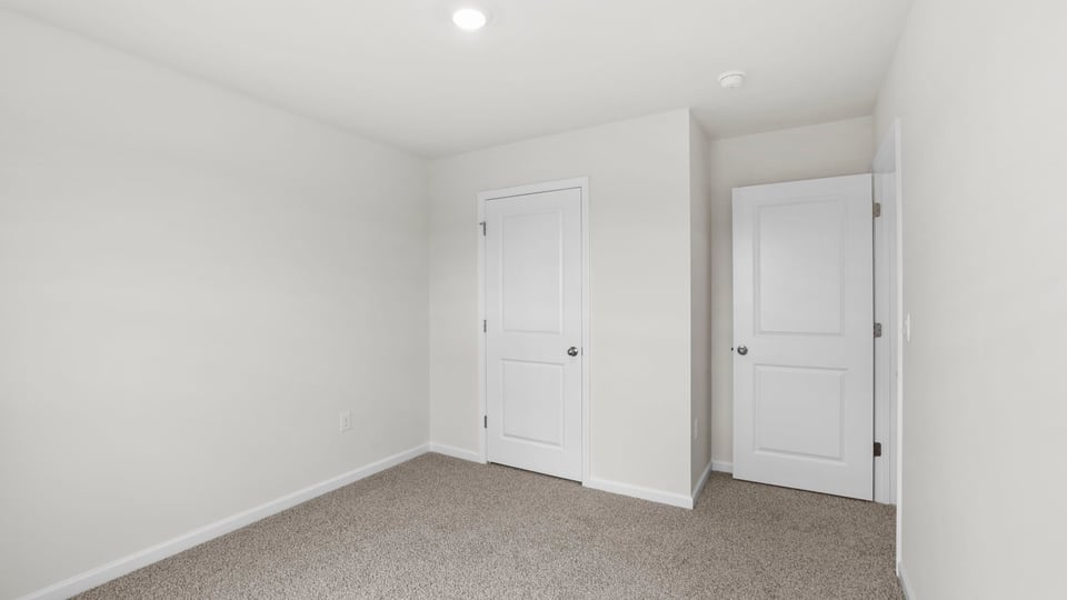 Bedroom with carpet and window.