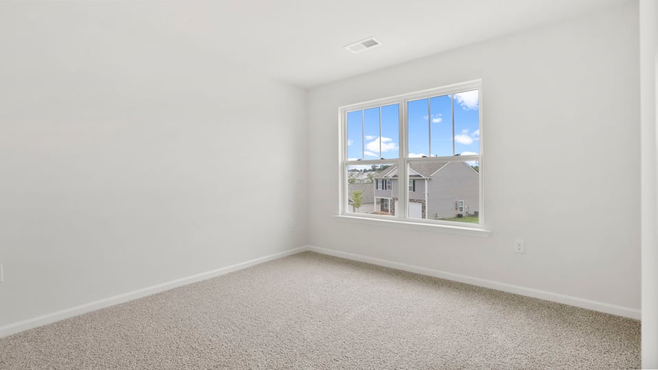 Bedroom with carpet and window.