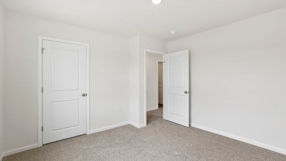 Bedroom with carpet and window.
