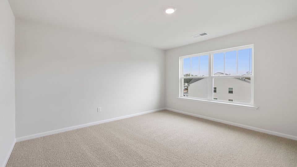 Bedroom with carpet and window.