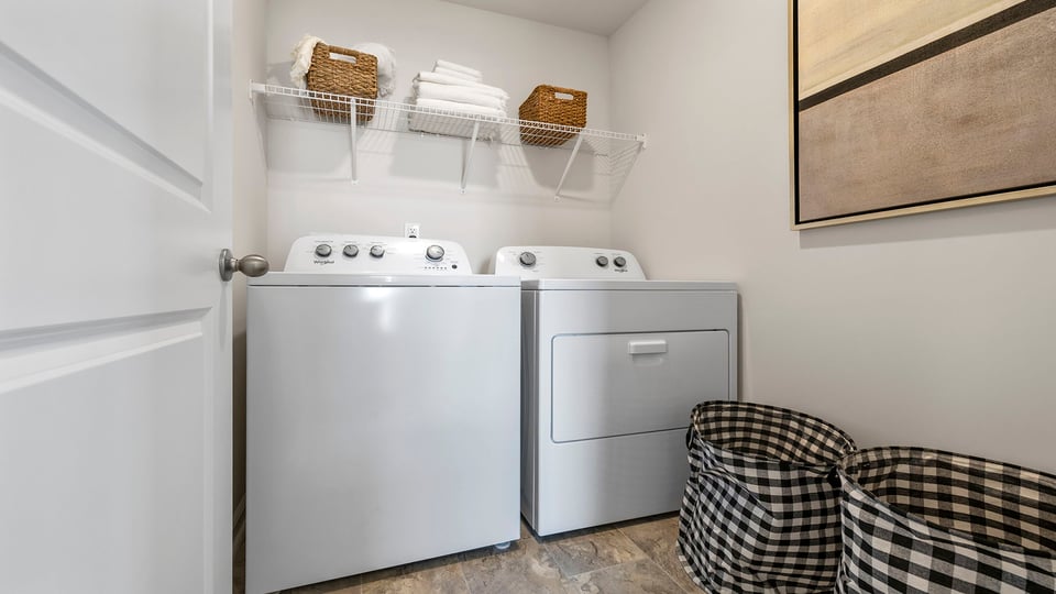 Laundry room with hanging storage racks.