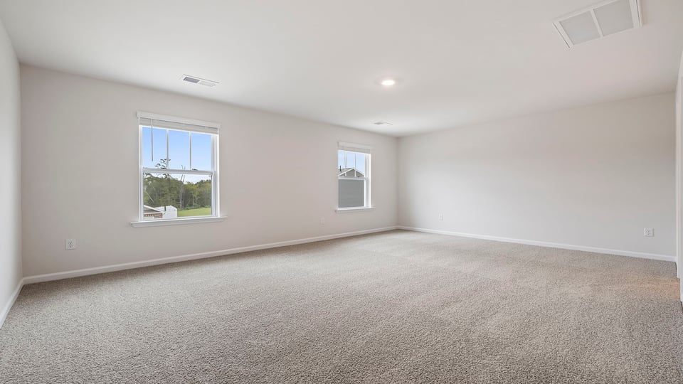 Bedroom with carpet and windows.