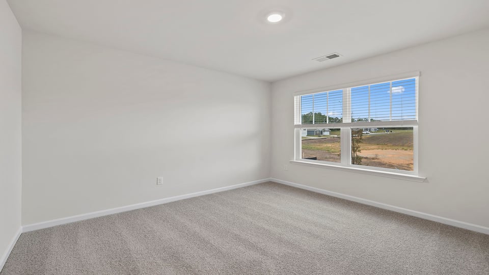 Bedroom with carpet and windows.