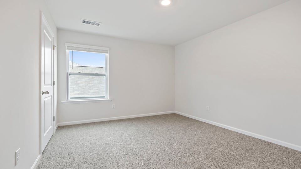 Bedroom with carpet and window.