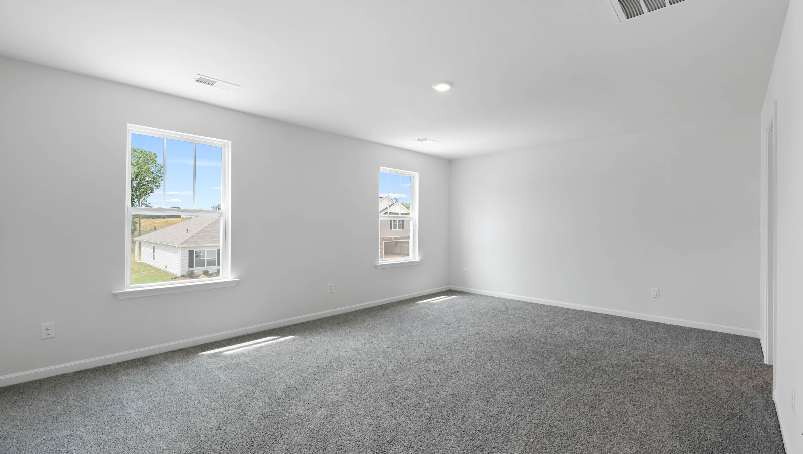 Bedroom with carpet and windows.