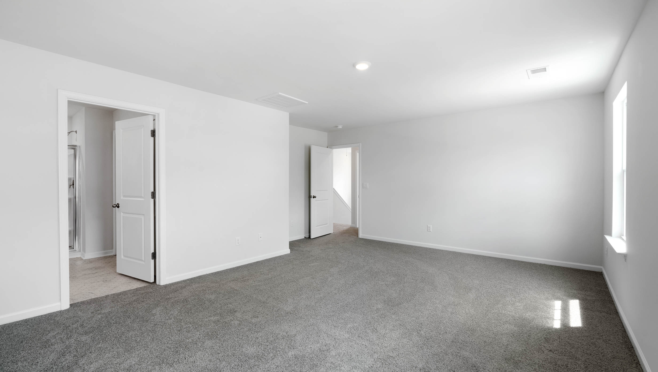 Primary bedroom with carpet.