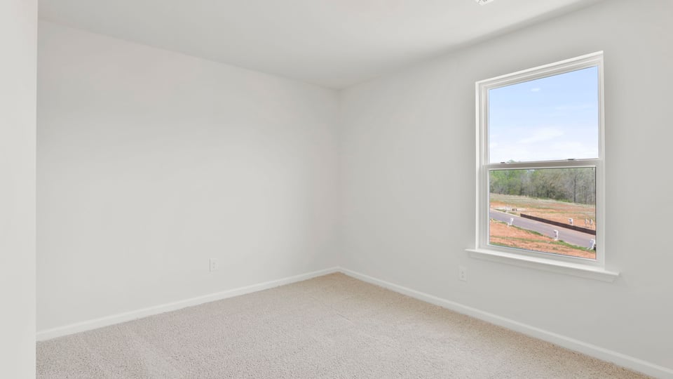 Bedroom with carpet and window.