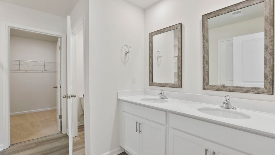 Bathroom with double vanity sink and walk in closet.
