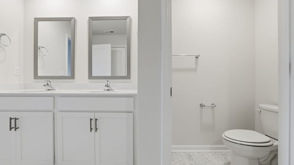 Bathroom with double vanity and walk in shower.