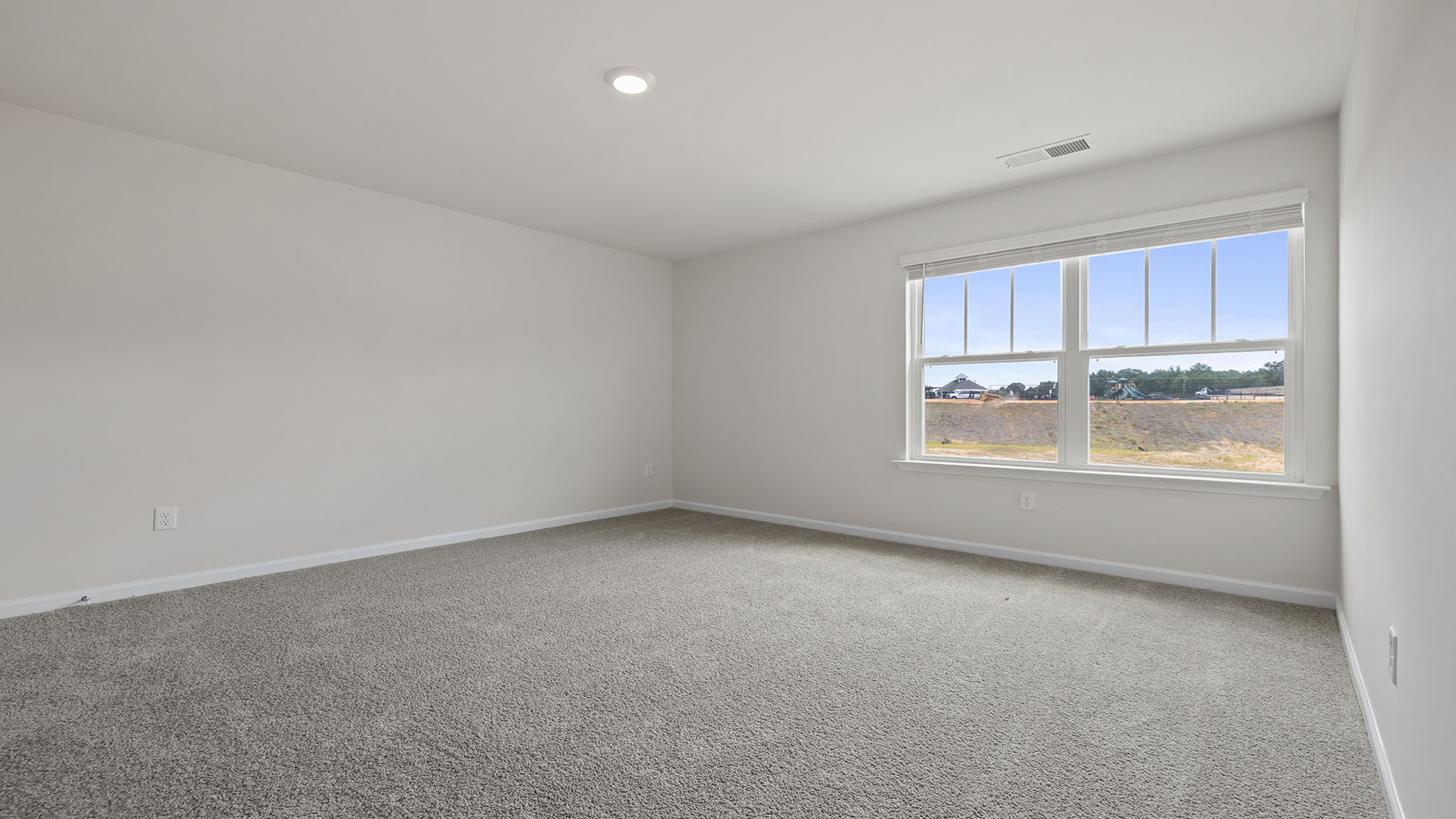 Bedroom with carpet and windows.