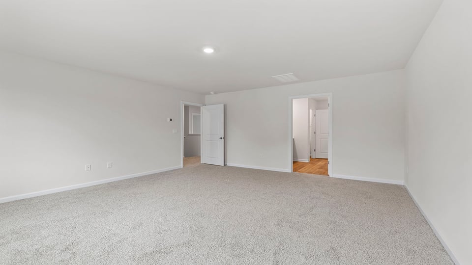 Bedroom with carpet and windows.