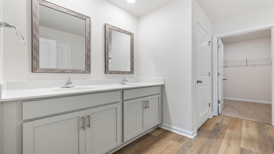 Bathroom with double vanity sink and walk in closet.