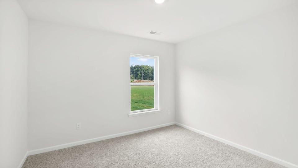 Bedroom with carpet and window.