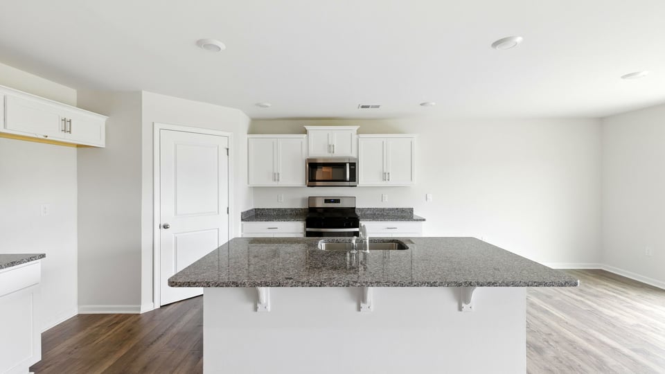 Kithcen with island and granite countertops.