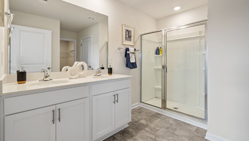 Primary bathroom with double vanity sink and walk in shower.