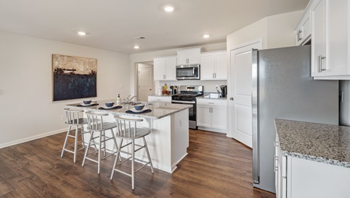 Kitchen and island with stainless steel appliances.