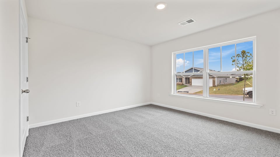 Bedroom with carpet and window.