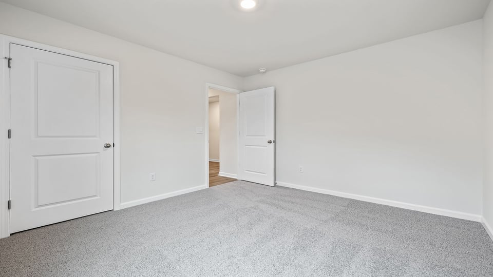 Bedroom with carpet and window.