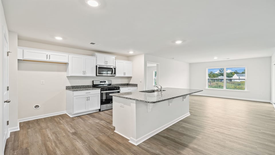 Kitchen and island with stainless steel appliances.
