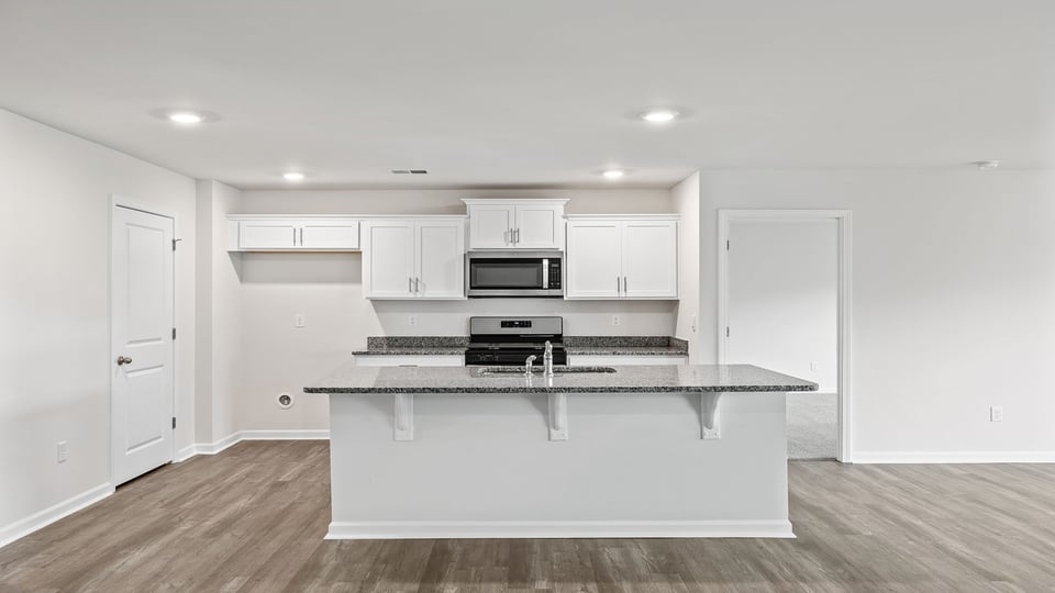 Kitchen and island with stainless steel appliances.