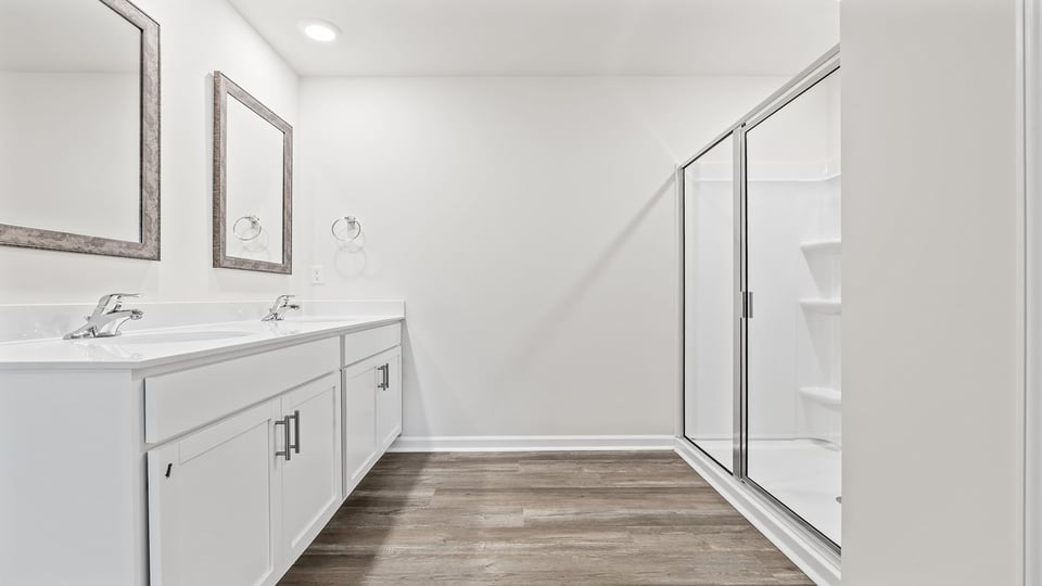 Bathroom with walk in shower and double vanity sink.