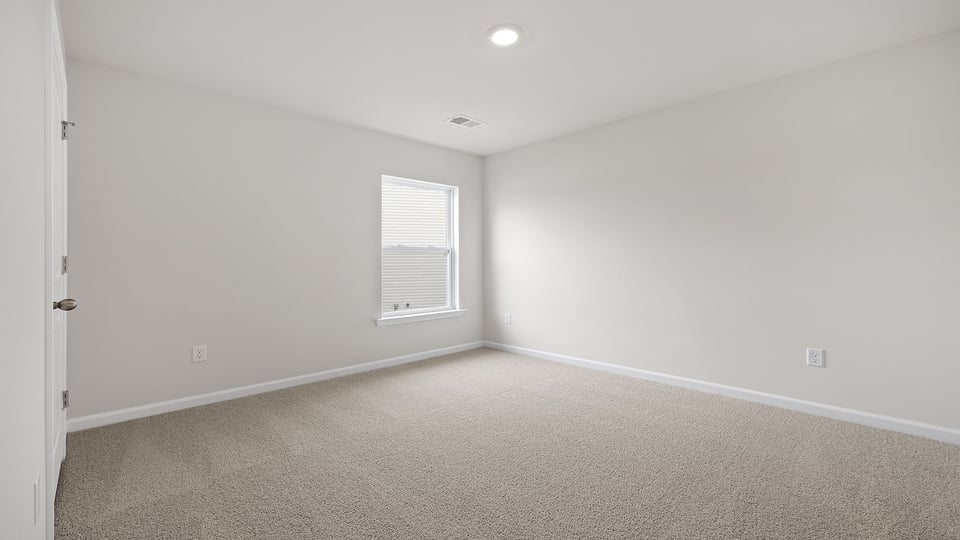 Bedroom with carpet and window.