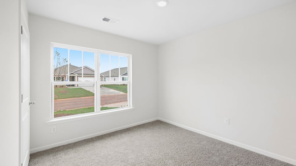 Bedroom with carpet and window.