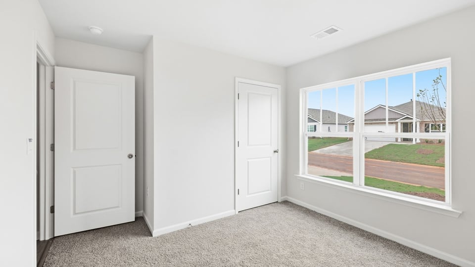 Bedroom with carpet and window.
