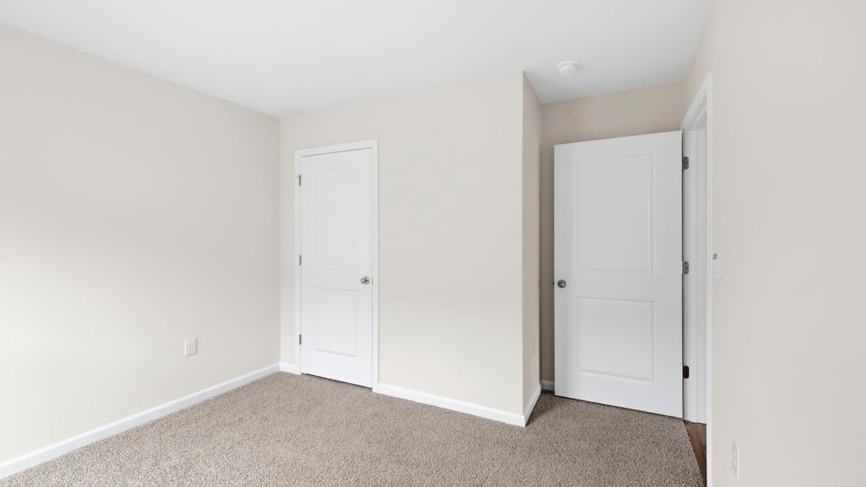 Bedroom with carpet and window.