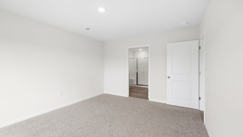Bedroom with carpet and windows.