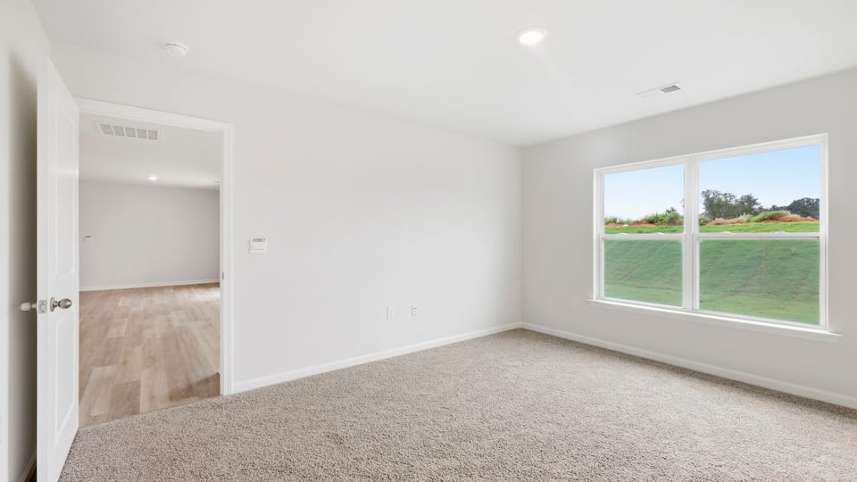 Bedroom with carpet and windows.