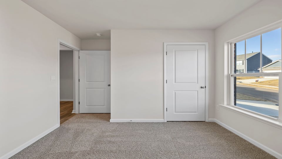 Bedroom with carpet and windows.