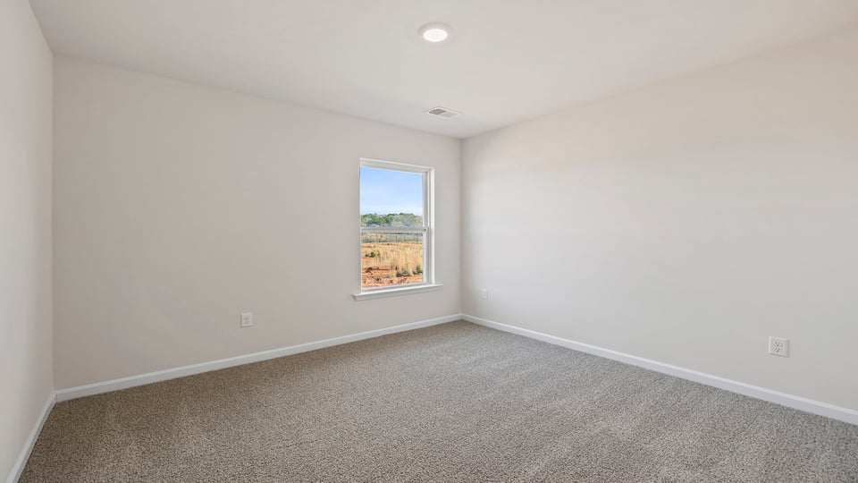 Bedroom with carpet and windows.