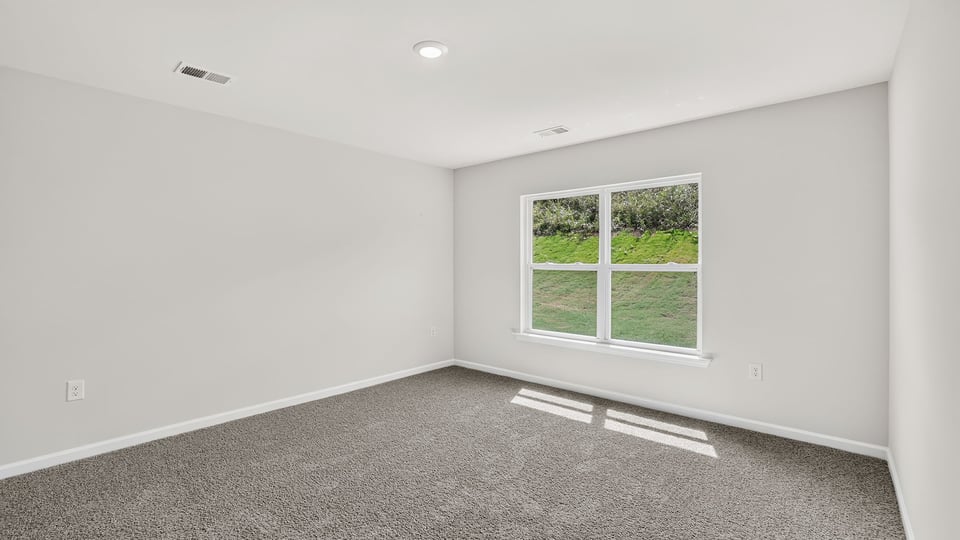 Bedroom with carpet and window.