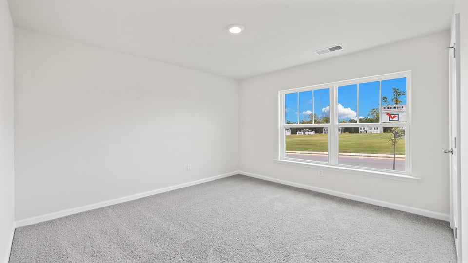 Bedroom with carper and windows.