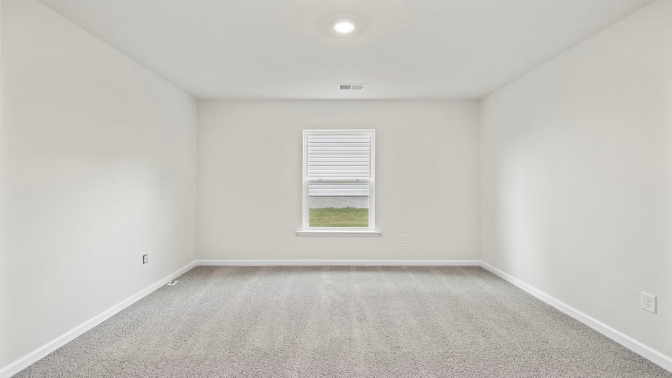 Bedroom with carper and windows.