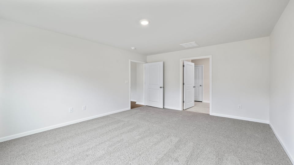 Bedroom with carper and windows.