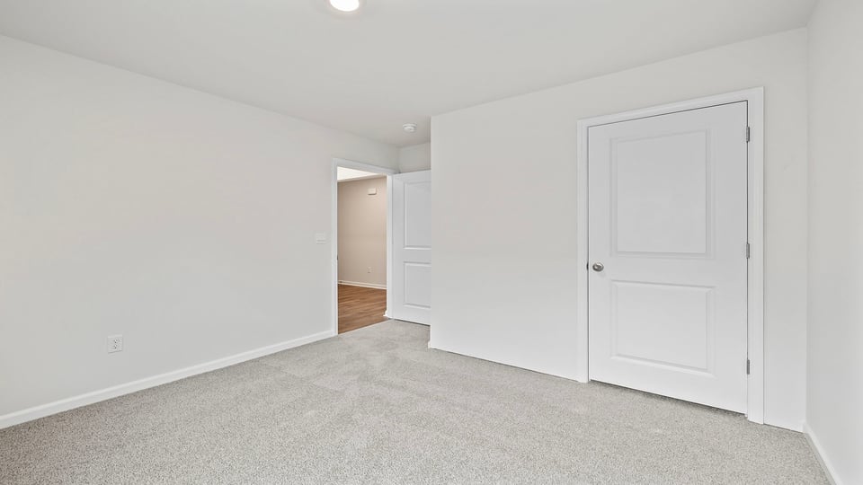 Bedroom with carpet and windows.