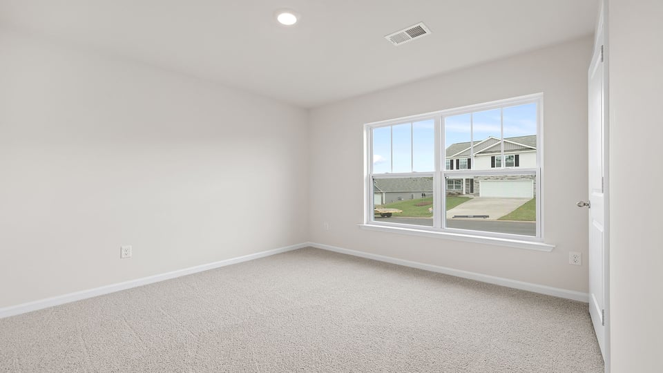 Bedroom with carpet and window.