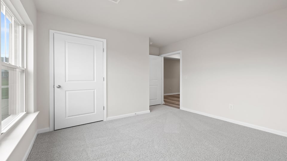 Bedroom with carpet and window.