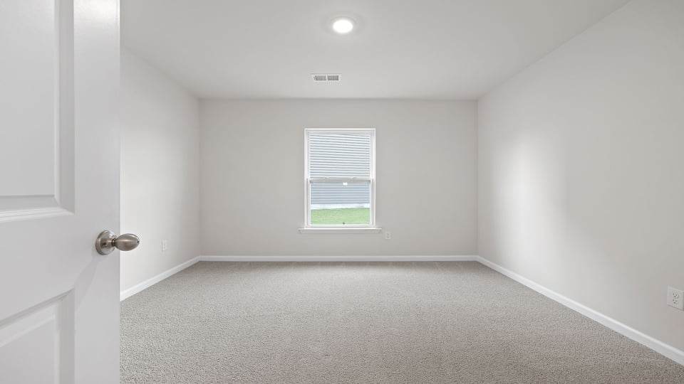 Bedroom with carpet and window.