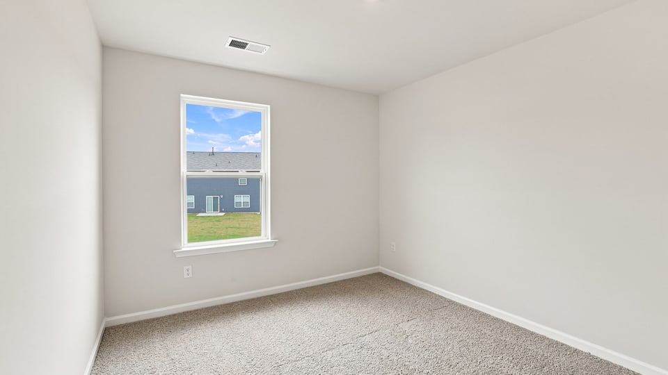 Bedroom with carpet and window.