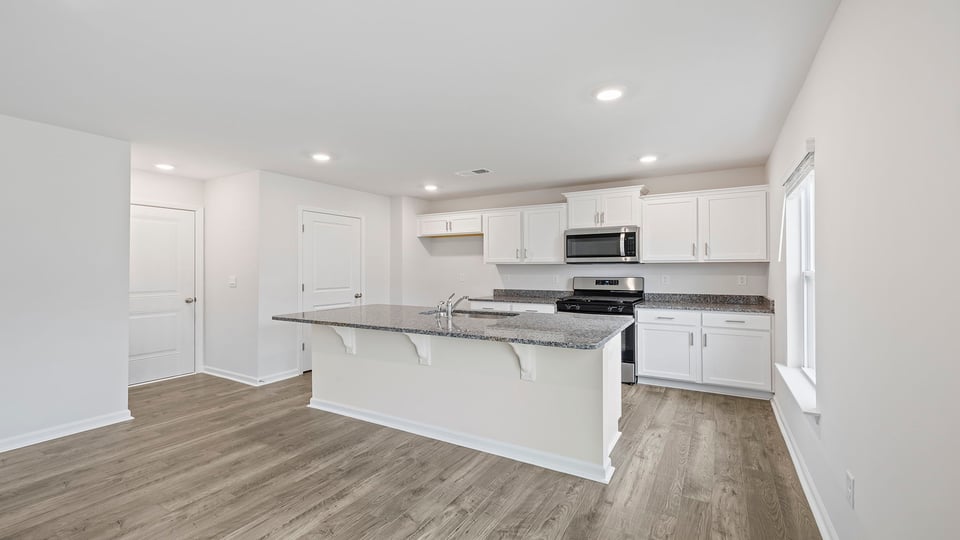 Kitchen with island and granite countertops.