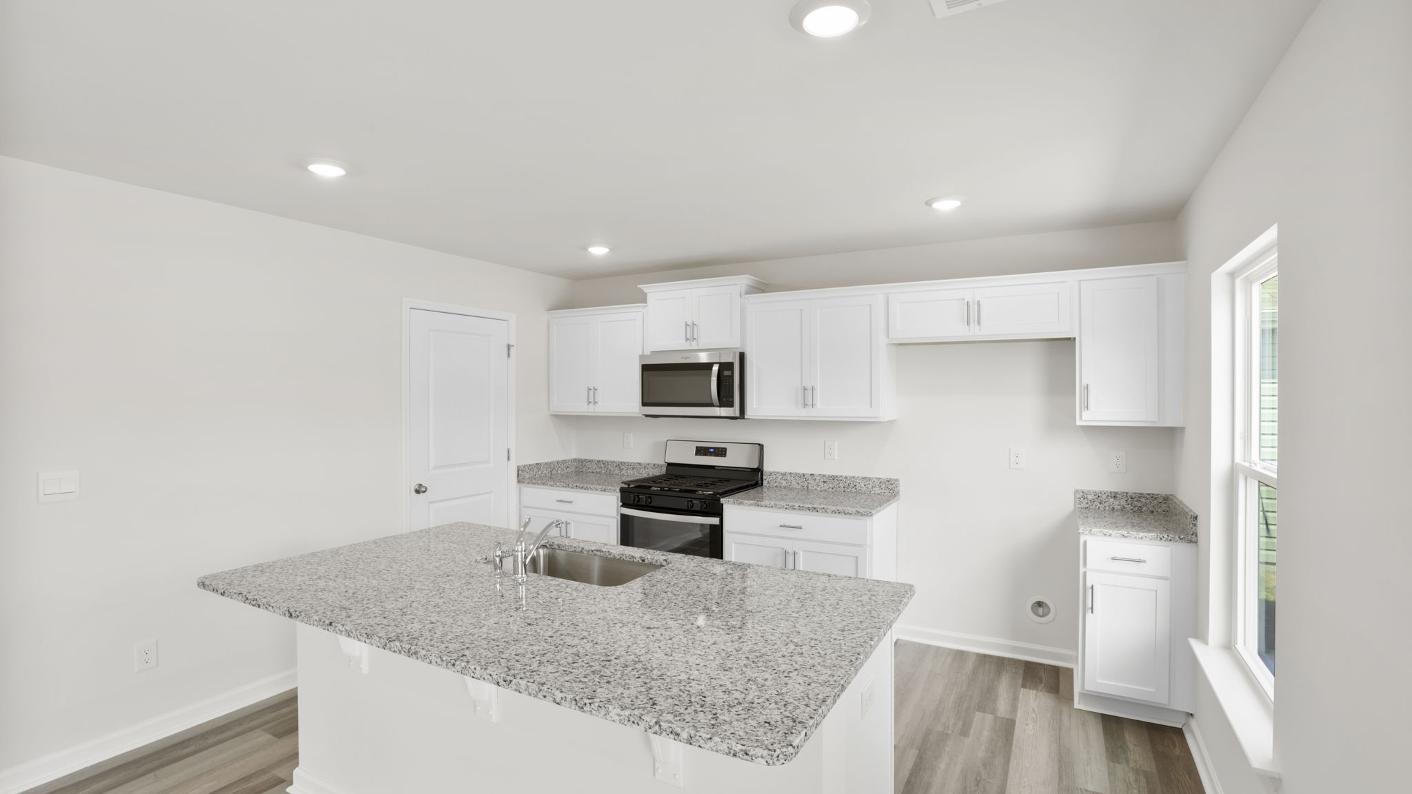 Kitchen with quartz countertops and stainless steel appliances.