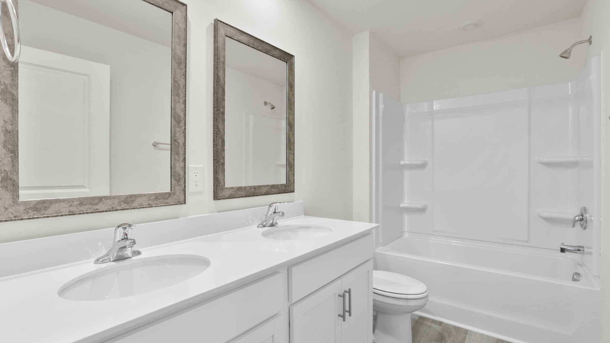 Bathroom with double vanity sink and tub.
