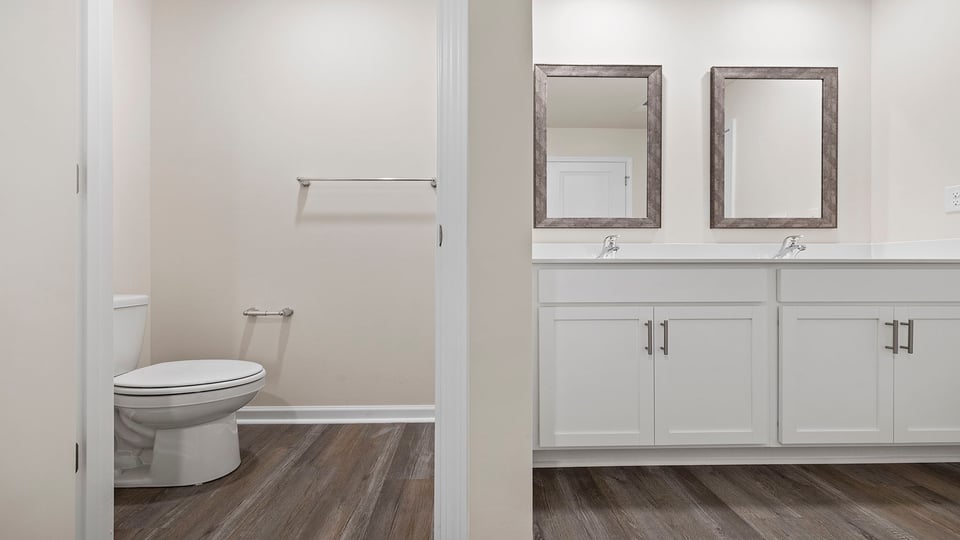 Bathroom with double vanity sink and toilet.